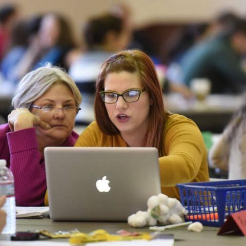 two women looking at a computer together